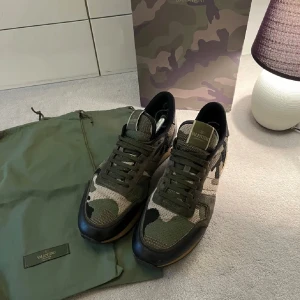 Valentino Rockrunner i camouflage - Snygga unika Valentino Rockrunner sneakers i ett skitsnyggt camouflage-mönster. Skorna har en kombination av gröna och svarta nyanser med snörning och en robust sula. Sjukt bekväma skor som passar i alla väder. Skorna är använda ett fåtal gånger och är näst intill nyskick. Skorna  är i storlek 43 men passar även 44. Box och dustbag medföljes tillsammans med skorna. Hör av er vid frågor eller funderingar!