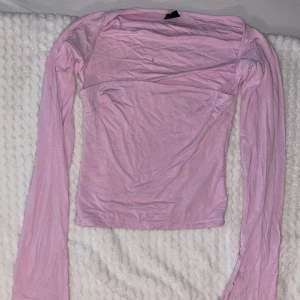 Rosa långärmad topp - Säljer en söt rosa långärmad topp med en enkel design. Perfekt för en avslappnad stil. Toppen har en mjuk och bekväm passform. Liten fläck på ryggen men den syns knappast.