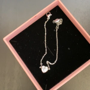 Silverarmband med hjärta från Edblad - Elegant silverarmband från Edblad med ett fint hjärthänge. Armbandet har en justerbar kedja och en säker klolås. Perfekt för att ge en subtil glans till din outfit.