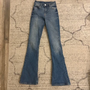 Blå bootcut jeans från Gina Tricot - Blåa bootcut jeans från Gina Tricot. Medel/hög midja i storlek XS. Tyckte om jeansen men dom blev för korta på mig som är runt 167cm lång med långa ben.
