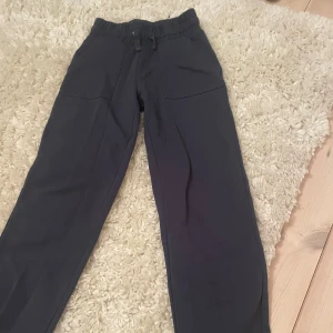 Svarta mjukisbyxor med resårmidja - Säljer ett par mörkblåa mjukisbyxor med resårmidja och snörning. Byxorna har fickor både fram och bak. Är lite noppriga på insidan av låret men det syns inte när man har på sig dom. Ganska bra skick då de bara är använda fåtal gånger. Pris kan diskuteras.