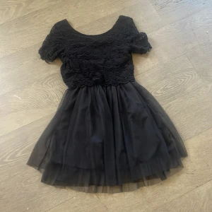 Svart klänning med spets och tyllkjol - Säljer en elegant svart klänning med korta ärmar och vacker spetsdetalj på överdelen. Kjolen är i luftig tyll som ger en fin volym. Perfekt för en festlig kväll! 🖤 Finns inte att köpa nånstans längre❤️