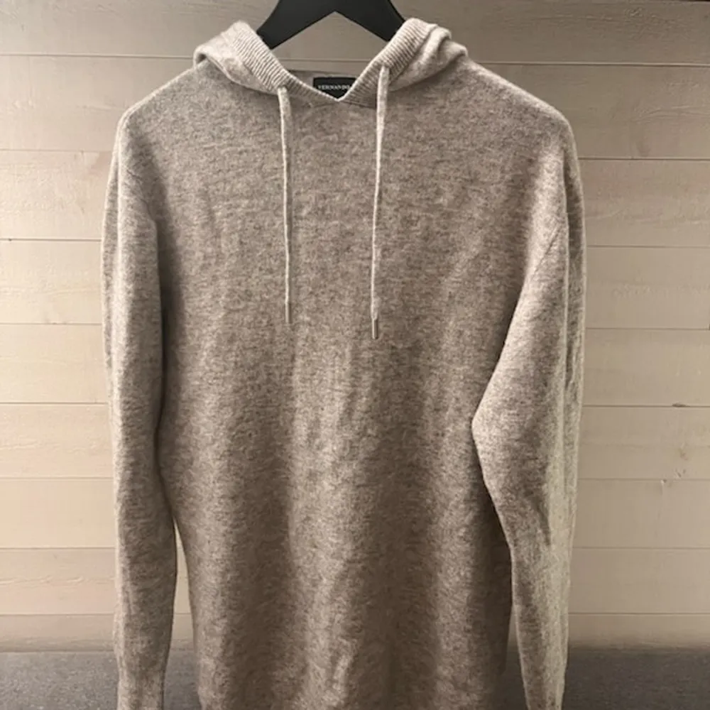 Säljer en stilren kashmir hoodie från Vernando. Den är tillverkad i ett mjukt material och har en klassisk design med dragsko i huvan. Perfekt för en avslappnad look.. Neuletakit & Villapaidat.