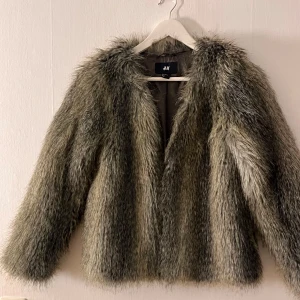 Gråbrun melerad pälsjacka, stl 34/xs - En så snygg fuskpäls-jacka i en gråbrun melerad färg, tyvärr är den lite för tight för mig… Jackan är i stl 34/xs och i superfint skick, endast använd fåtal gånger. Från H&M men finns inte att köpa på hemsidan längre.
