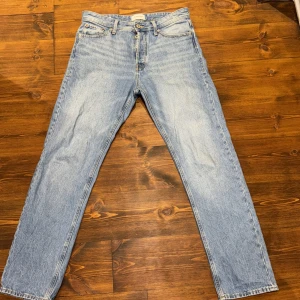 Blå jeans från Jack & Jones - Säljer ett par ljusblå jeans från Jack & Jones med en relaxed fit. Modellen heter Chris och har en klassisk femficksdesign. Perfekta för en avslappnad stil. Använda max 5 gånger!