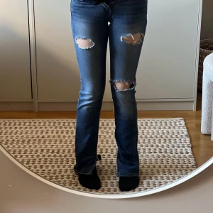 Blå jeans från Crocker - Snygga blå jeans från Crocker med slitna detaljer på låren. De har en straight passform och är tillverkade i denim. Perfekta för en avslappnad stil.