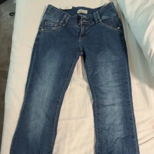 Lågmidjade jeans  - Säljer dessa helt oanvända jeans med tre jätte snygga knappar. Midjemått 36, inrebenlängd 84, utsvängda och lågmidjade