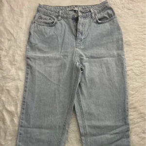 Ljusblå jeans från NA-KD - Säljer ett par ljusblå jeans från NA-KD. De har en klassisk femficksdesign och är tillverkade i ett bekvämt denimtyg. Perfekta för en avslappnad stil.