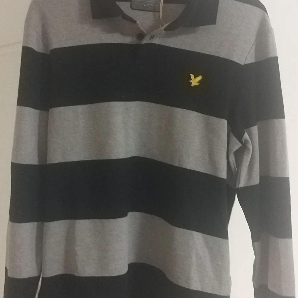 En långärmad tröja från Lyle & Scott. Svart randig pikétröja.