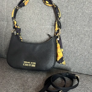 Svart axelväska från Versace Jeans Couture - Säljer en svart axelväska från Versace jeans couture. Den är i fint skick och inga större fel med den. Pris kan diskuteras