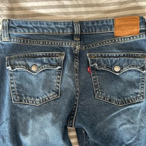 Blå jeans från Levi's - Säljer ett par blå bootcut Levi’s jeans med fickor med knappar på baksidan💙