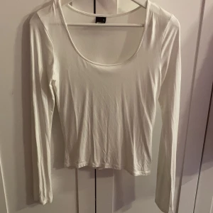 Vit långärmad topp från Gina Tricot - Säljer en stilren vit långärmad topp från Gina Tricot. Toppen har en rund halsringning och är tillverkad i ett mjukt material som ger en skön passform. Perfekt för lager-på-lager eller som den är. Den har även en liten detalj längst ner på ärmen🖤