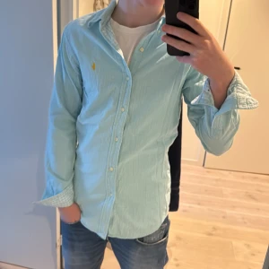 Ljusblå skjorta från Polo Ralph Lauren - Säljer en vintage skjorta från Polo Ralph Lauren i färgen turkos. Passar perfekt till sommaren. Hör av dig vid minsta lilla fråga👍🙏