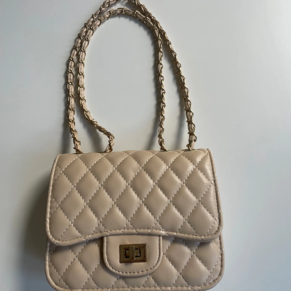 Beige quiltad axelväska