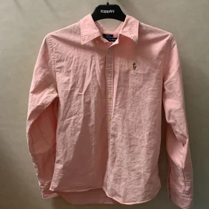 Ralph lauren skjorta  - Stilren rosa Ralph lauren skjorta i storlek small skjortan ser lite ostruken ut men blir strykt efter innan de postas. Nypris 1400kr.  mitt pris 399. Pris kan också diskuteras men hör gärna av dig vid minsta fundering eller övrigt hälsningar Alex 
