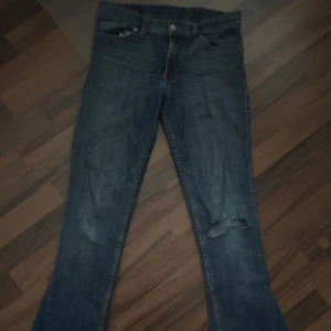 Blå jeans från Levis - Säljer ett par klassiska blå jeans från Levis med en slitning på ena benet. 