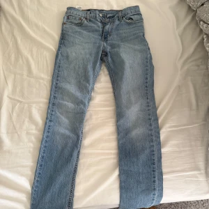 Levis 501 jeans i ljusblå denim - Klassiska Levis 501 jeans i ljusblå denim. De har en rak passform och är tillverkade i slitstarkt jeanstyg. Perfekta för en avslappnad stil med fem fickor och knappgylf.