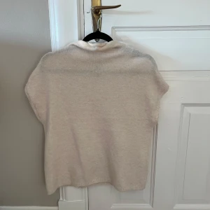 Beige stickad tröja från Lindex - Säljer en mjuk och stilren beige stickad tröja från Lindex. Perfekt för kyligare dagar med sin bekväma passform och enkla design. Ett måste i garderoben för en avslappnad look.