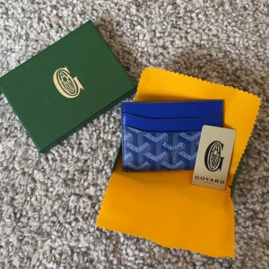  Korthållare Blå - Säljer en snygg blå snygg korthållare. Korthållaren har flera fack för kort och är perfekt för att hålla ordning på dina tillhörigheter. Kommer med förpackning.