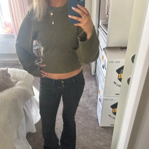 Olivgrön croppad tröja - Säljer en olivgrön croppad tröja med långa ärmar. Tröjan har en ribbad kant vid midjan, och vida armar, sitter så snyggt verkligen!! Använd enstaka gång så är i nyskick!❤️‍🔥