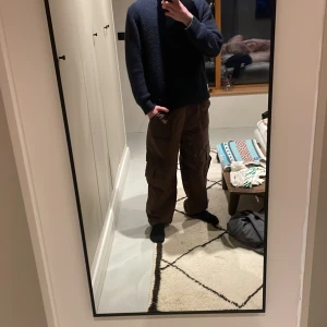 Bruna cargobyxor från Zara - Säljer ett par schyssta bruna cargobyxor från Zara. Byxorna en loose passform som ger en avslappnad stil. Perfekta för en casual look. Tillverkade i ett slitstarkt material. Väldigt sköna och funkar till mycket. 