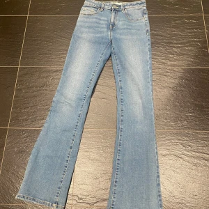 Blå bootcut jeans från Bailey - Snygga blå bootcut jeans från Bailey. De har en klassisk femficksdesign och en knappgylf. Endast använda ett fåtal gånger. Säljs på flera sidor.                  Mått: Midja: 33cm. Innerbenslängd: 77 cm Gren: 23cm