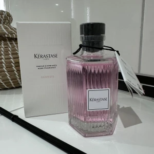 Kérastase Genesis  - Elegant doftspray från Kérastase, Genesis Edition. Flaskan är stilrent designad i glas med en ljusrosa vätska och svart kork. Perfekt för att skapa en lyxig atmosfär i hemmet. Tillkommer med doftpinnar