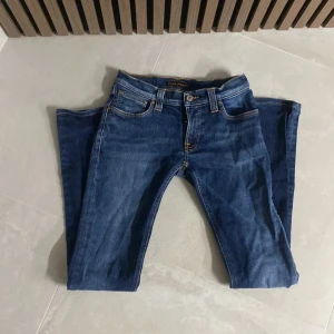 Blå jeans från Nudie Jeans - Snygga blå jeans från Nudie Jeans med klassisk femficksdesign. skick 9/10. Slim passform. Säljer pga för små.