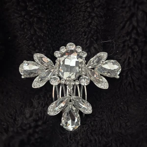 Glittrig hårkam med kristaller - Elegant hårkam i silverfärg med gnistrande kristaller i olika former. Perfekt för att ge en extra touch av glamour till din outfit.