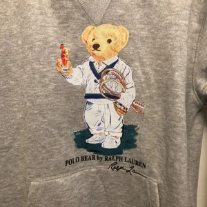 Grå hoodie från Ralph Lauren med Polo Bear - Säljer en grå hoodie från Ralph Lauren med Polo Bear-motivet. Nypris 2695 mitt pris är 1099. Jag fraktar inom 24 timmar vid detta plagg och möta inte upp. Kan sänka pris vid snabbköp. Det bara att skriva vid frågor👍👍