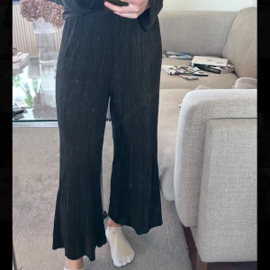 Svarta plisserade byxor - Snygga svarta plisserade byxor med en lös passform. Byxorna har en hög midja och vida ben. Byxorna är från Gina Tricot, har klippt bort lappen så kommer ej ihåg storlek men skulle säga att de sitter som en M.