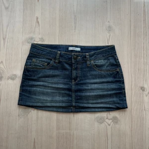 Blå lågmidjad jeanskjol  - Blå jeanskjol från Esprit i fint skick. Kan inte hitta storlek men skulle säga M, passar även S. Tvärs över midjan är det 42 cm och den är ca 31 cm lång (längs med sidan). Fint skick. Använd gärna köp nu!