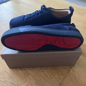 Mörkblå sneakers från Louboutin - Snygga mörkblå sneakers från Louboutin med lyxig mocka och klassisk röd sula med logotyp. Inte min stil därför säljer jag köpt till skolbalen. Pris kan diskuteras endast använd en kväll