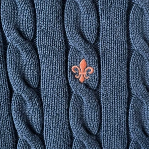 Blå kabelstickad tröja från Morris - Snygg blå kabelstickad tröja från Morris i storlek S, tillverkad av 100% bomull. Tröjan har ett klassiskt mönster med grova flätor och en orange broderad logga på bröstet. Rund hals och långa ärmar gör den perfekt för kyliga dagar.