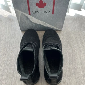 Svarta mockakängor från Canada Snow - Säljer ett par feta Canada Snow i storlek 43 som är perfekt till vintern. De håller sig riktigt varma och är perfekt för en stilren outfit i vinter. De är använda fåtal gånger och är som nya
