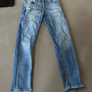 Jack N Jones jeans - Säljer ett par jeans med tapered fit. Jeansen har snygga slitningar och kontrastsömmar, fem fickor och raka ben. Perfekt passform för dig som gillar en modern och avslappnad stil. Storlek 31/32. Jeansen är flared
