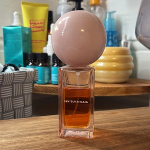 Senteur de Caia parfym  - Parfym från CAIA med en unik design – fyrkantig glasflaska med orange vätska och en stor, matt ljusrosa rund kork. Flaskan har en modern och stilren look som sticker ut på hyllan. Perfekt för dig som gillar snygga detaljer i badrummet.50ml flaska