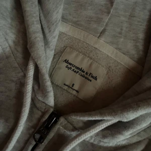 Abercrombie & Fitch hoodie - super söt lite kortare hoodie där det även står Abercrombie & Fitch på hoodiens luva och längst nere vid fickan. köpte den på plick men har knappt använt den, inga tecken på användning. priset kan diskuteras!!!