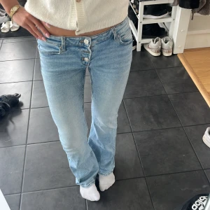 Ljusblå bootcut jeans med knappar - Säljer ett par ljusblå jeans med snygg bootcut passform. Sparsamt använda. Storlek 158 och passar mig som är 161.
