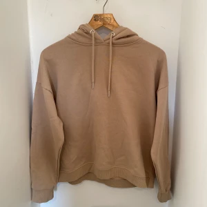 Beige hoodie med huva och snörning - Säljer en beige hoodie med huva och snörning. Jag köpte den 2023 och har använt den 1-2 gånger då jag inte gillar att ha tröjor med huva. Storlek L men känns mindre🤍 Mjukt material