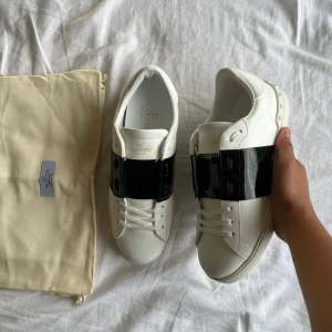 Valentino Open svartglans - Snygga Valentino Garavani Open sneakers i svart glans. Storlek 41 sitter 41-41,5. skick 10/10 ej använda. Tillbehör/OG Skobox, Dustbag och även kassen. NYPRIS 7’200kr