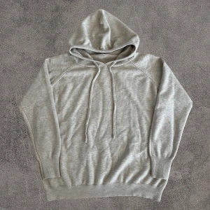 Kashmir Hoodie beige - Snygg beige Kashmir hoodie med huva och snörning framtill. Tröjan har långa ärmar och ribbade muddar vid ärmslut och nederkant. Materialet känns mjukt och är Kashmir , perfekt för chill dagar. Enkel och stilren design utan tryck eller mönster.