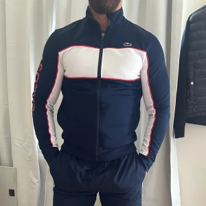Tränings set - Snyggt set från Lacoste i nytt skick! Tröjan är i storlek S och byxorna i storlek M. 