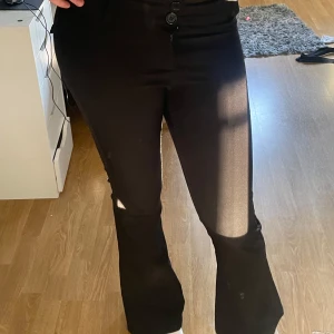 Svarta bootcut-kostymbyxor - Snygga svarta bootcut-byxor från Gina Tricot med två knappar i midjan. Byxorna har en klassisk bootcut-passform och är gjorda i ett mjukt material som sitter skönt. Perfekta för dig som gillar stilrena och trendiga byxor. Inga hål eller sånt och är använda runt 5 gånger. Säljer för jag tycker att den är lite för kort på mig🥰ordinarie priset är 500kr😇
