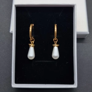 Guldörhängen med vita pärldroppar - Snygga örhängen med guldfärgade ringar och hängande vita pärldroppar. Rostfritt stål. 