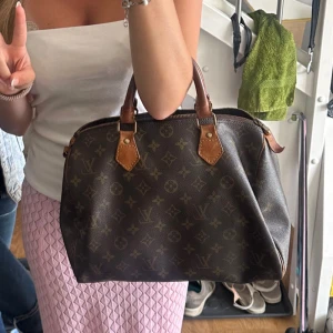 Louis Vuitton handväska Speedy - Säljer en klassisk brun handväska från Louis Vuitton med ikoniskt monogrammönster och detaljer i ljusbrunt skinn. Väskan har två handtag och dragkedja upptill, perfekt storlek för att få plats med allt du behöver. Den är nästan nyköpt från Soleplus och äkthetbevis finns. Det är inga tydliga defekter eller liknande. Skriv privat vid frågor, fler bilder osv💗💗