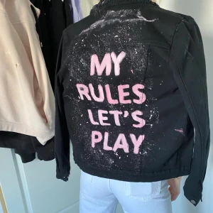 Jeansjacka - En skit cool jeansjacka med text ”my rules lets play” från insta konto byemilja. Aldrig använt eftersom inte min typ av stil. Super fint skick, nypris 550kr. Frakt ingår ej i priset! Pris kan diskuteras