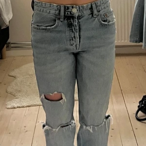Ljusblåa slitna jeans - Snygga ljusa slitna jeans. Med hål och en straight passform