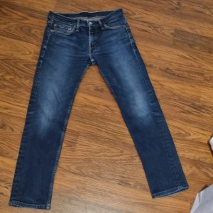 Levi's 511 mörkblå jeans W30 L32 - Säljer ett par Levi's 511 jeans i mörkblå tvätt med klassisk femficksdesign. Jeansen har normal passform med något smalare ben.  Det finns även inga defekter förutom lappen på baksidan. Perfekta nu till hösten. Pris går att diskuteras vid snabb affär!