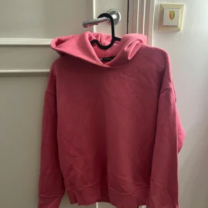 Rosa hoodie från Zara med huva - Säljer en chill rosa hoodie från Zara i storlek S. Tröjan har en stor huva, långa ärmar och breda muddar vid ärmslut och nederkant. Materialet är mjukt och känns som bomull, perfekt för att slänga på sig när man vill vara bekväm. Färgen är en snygg ljusrosa ton.